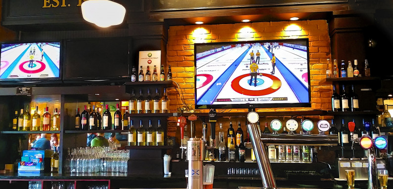 Curling on television in a bar